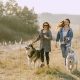 two women running with their huskies on leashes